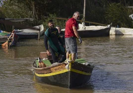 Dos buceadores de los GEAS en una las embarcaciones de un pescador de La Albufera.