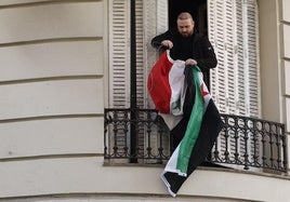 Una persona coloca la bandera insurgente en la embajada de Siria en Madrid.