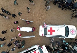 Vista aérea que muestra a miembros de la Cruz Roja recibiendo un ataúd mientras militantes de Hamas entregan a los rehenes fallecidos Oded Lifschitz, Shiri Bibas y sus dos hijos Kfir y Ariel Bibas.