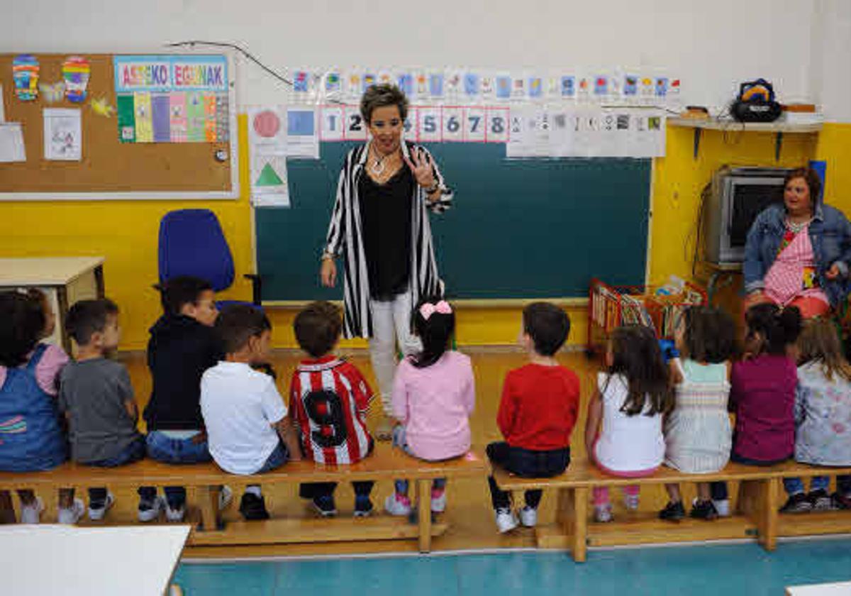 Una profesora dando clase a un grupo de niños.