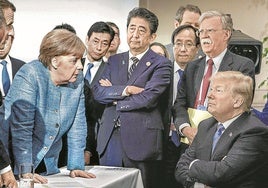 Donald Trump atiende con indiferencia a Angela Merkel durante una de las reuniones del G-7