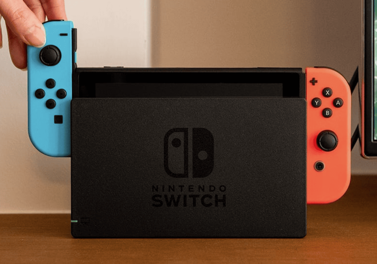 Nintendo switch con sus accesorios y adaptador.