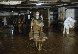 Decenas de voluntarios participan en los trabajos de limpieza de un garaje en Paiporta.