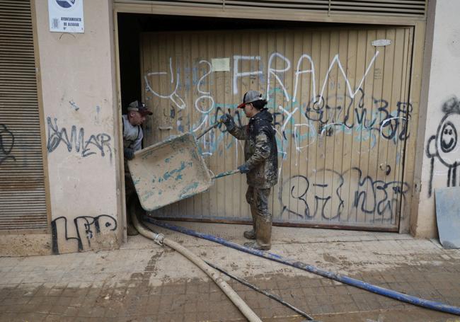 Operarios tratan de sacar el agua del garaje.