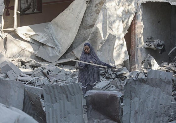 Una mujer palestina analiza los daños producidos por un ataque israelí este martes en el campo de refugiados de Nuseirat.