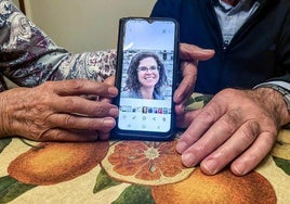 Los padres de Silvia, Isidoro y Loli, sujetan un móvil con la foto de su hija.