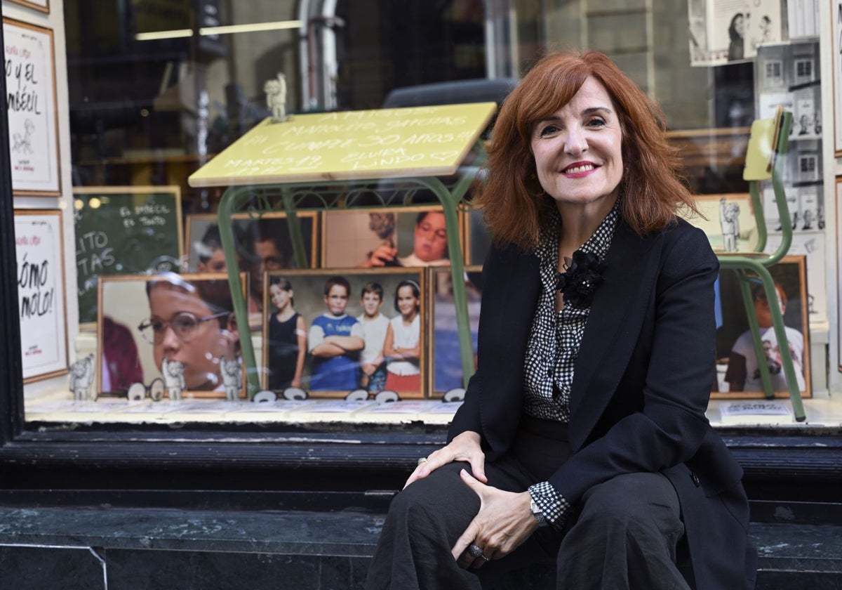 La escritora y periodista Elvira Lindo ante el escaparate de la librería La Mistral de Madrid, dedicado a Manolito Gafotas.