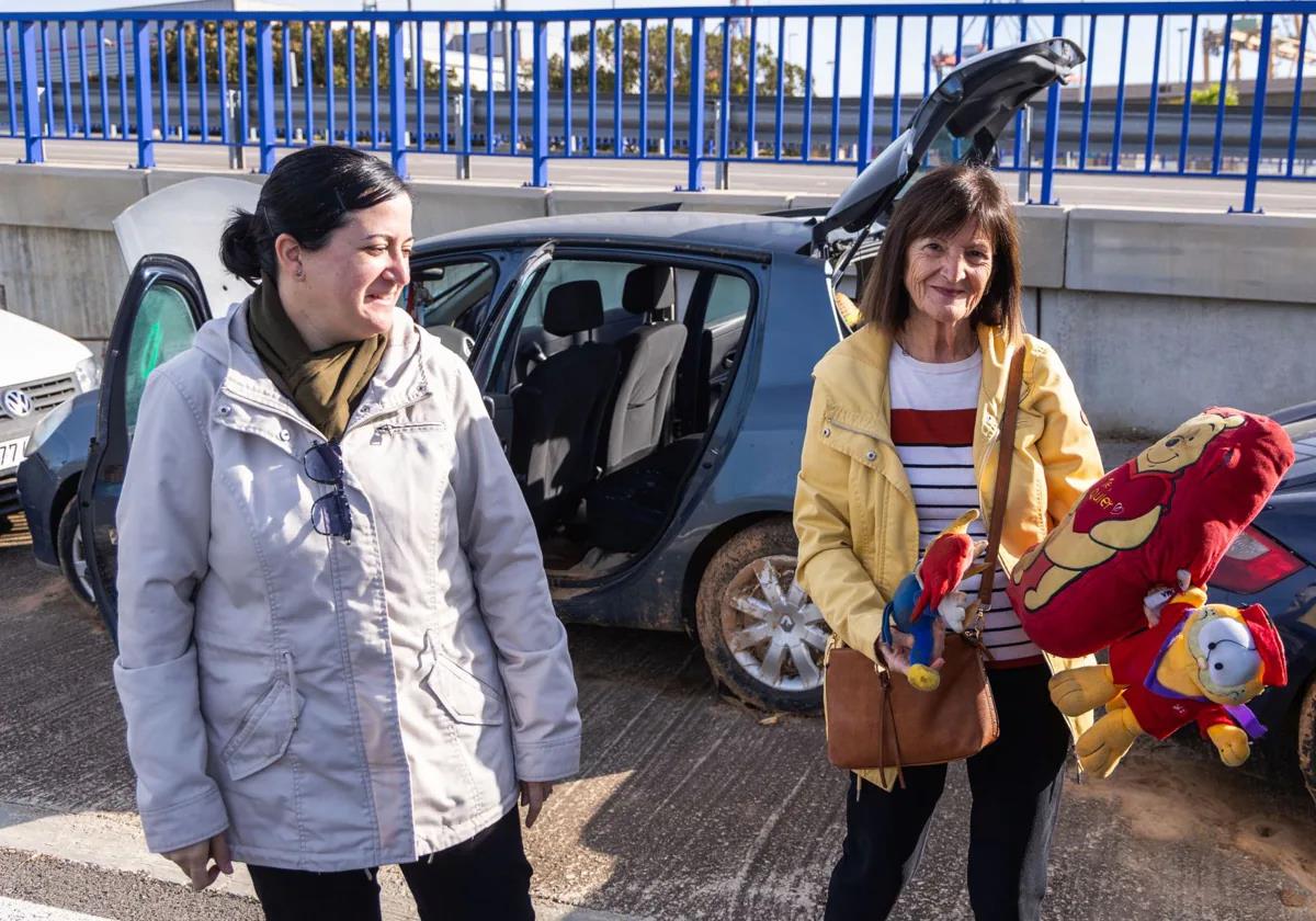 Esther Serrano, a la izquierda, junto a su madre y los peluches que han salvado del coche depositado en la ZAL del Puerto de Valencia.