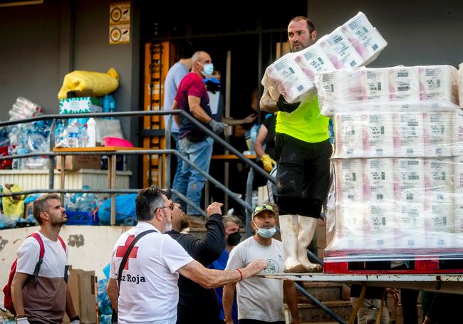 Voluntarios de Cruz Roja organizan la distribución de productos de primera necesidad para trasladarlos a las localidades de Massanassa, Alfafar y Benetusser.