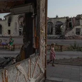 Una niña juega junto a unos edificios residenciales destruidos por bombardeos rusos en Donetsk.