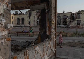 Una niña juega junto a unos edificios residenciales destruidos por bombardeos rusos en Donetsk.