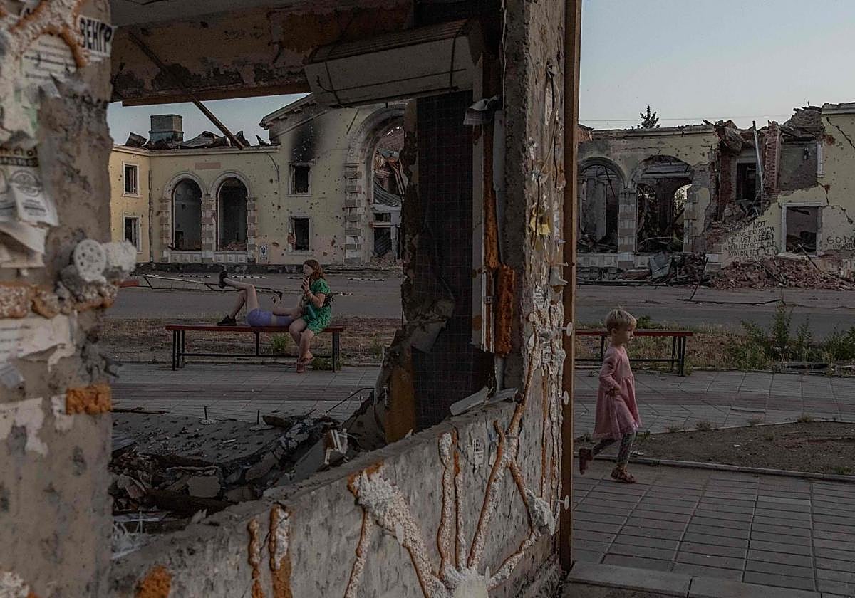 Una niña juega junto a unos edificios residenciales destruidos por bombardeos rusos en Donetsk.