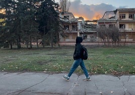 Una joven pasea junto a un edificio bombardeado por los rusos.