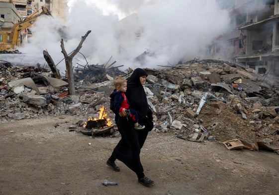 Una mujer camina junto a las ruinas de su antiguo barrio cerca de Tiro, en el sur de Líbano, bombardeado por Israel.