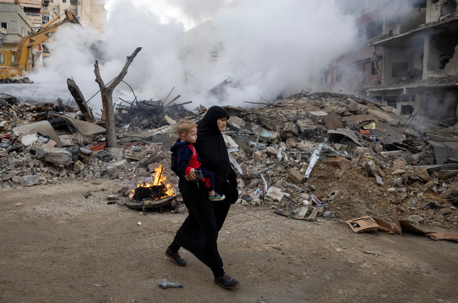 Una mujer camina junto a las ruinas de su antiguo barrio cerca de Tiro, en el sur de Líbano, bombardeado por Israel.