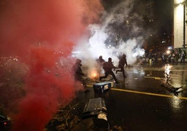 Policías antidisturbios intentan dispersar a los manifestantes que la noche del jueves trataron de rodear el edificio del Parlamento.