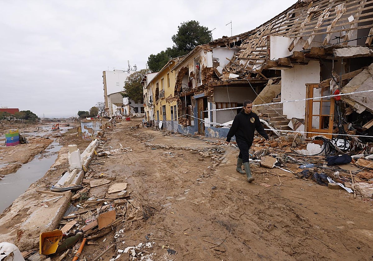 Un vecino pasa delante de las casas destrozadas junto al Barranco del Poyo, tras la trágica riada vivida el pasado 29 de octubre en Picanya.