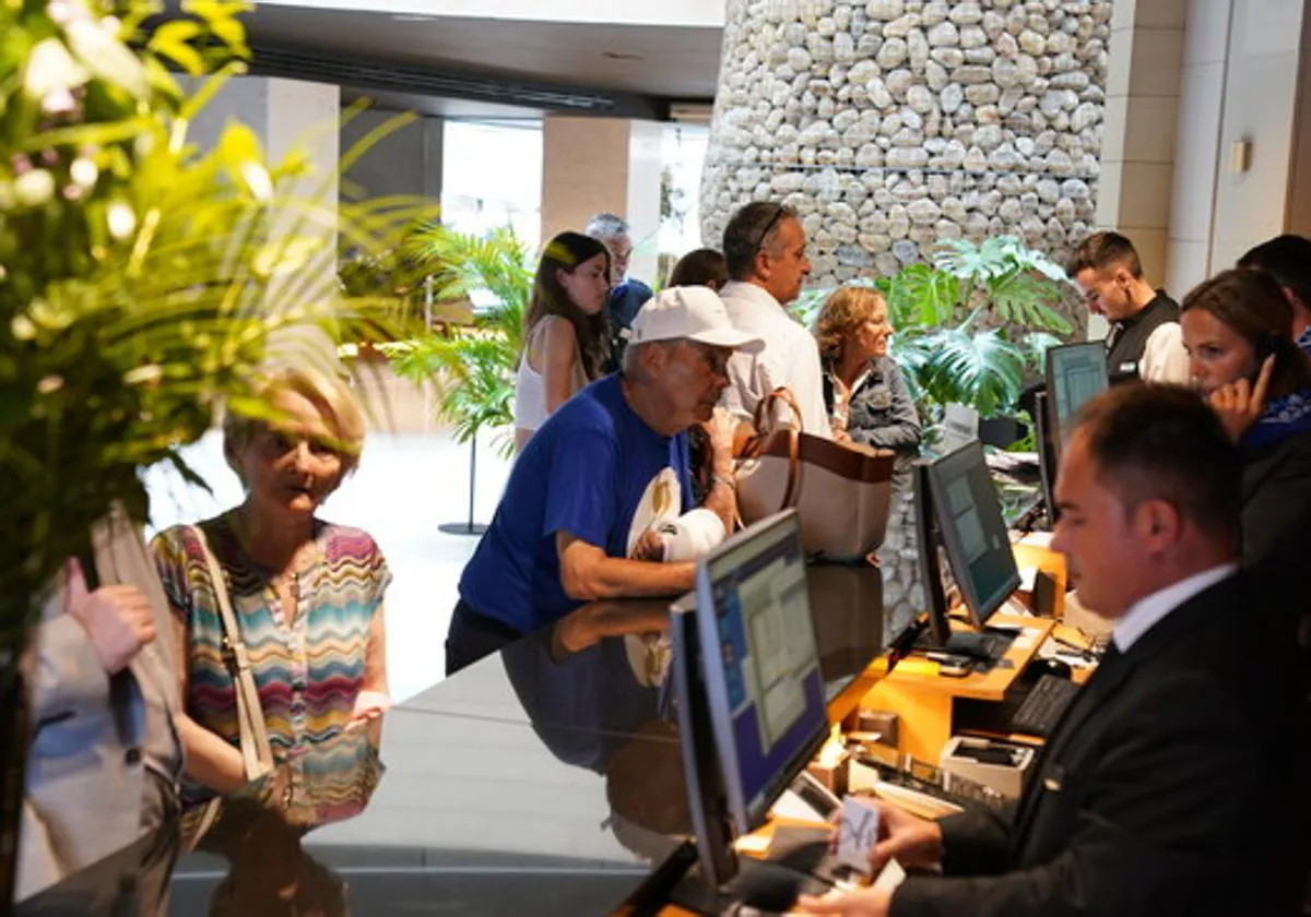 Turistas en la recepión de un hotel.