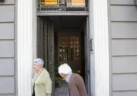 Ancianos en un edificio con pisos en venta.