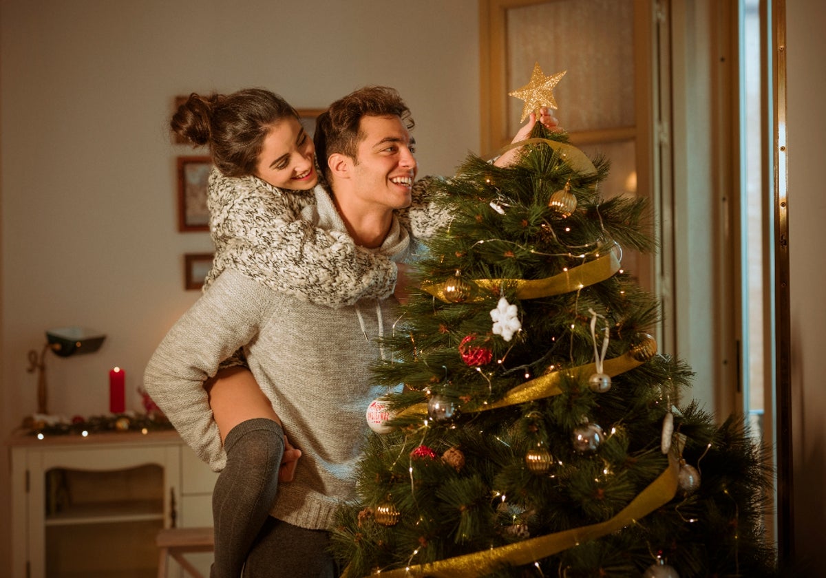 Disfrutando de la navidad en familia con árbol de navidad decorado con estrella en la punta.