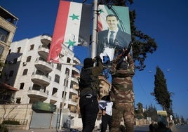 Rebeldes sirios rompen un retrato del presidente, Bashar al Assad en el centro de Alepo.