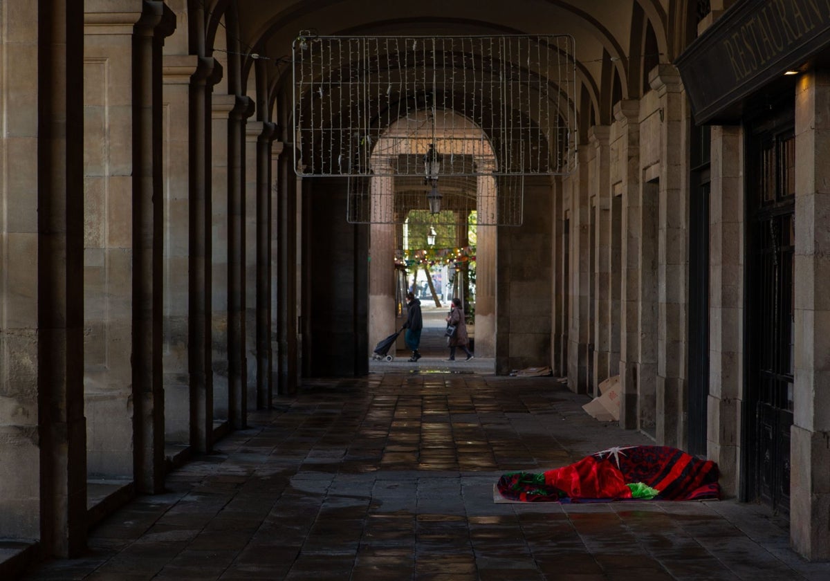 Una persona sin hogar duerme en el centro de Barcelona.