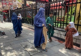 Mujeres afganas caminan con sus hijos por una calle de Kabul.