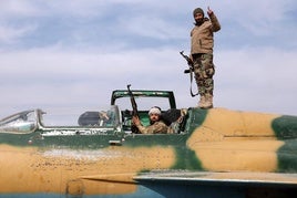 Dos rebeldes posan en un avión de combate tras tomar una base militar cerca de Hama.