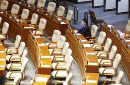 Un diputado del partido gubernamental permanece en su escaño tras la espantada de sus compañeros.