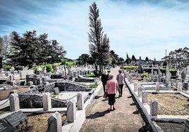 Varias personas visitan un cementerio.