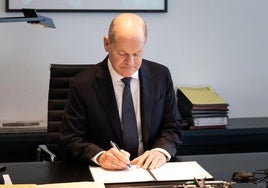 Olaf Scholz firma la petición de moción de censura en su despacho.