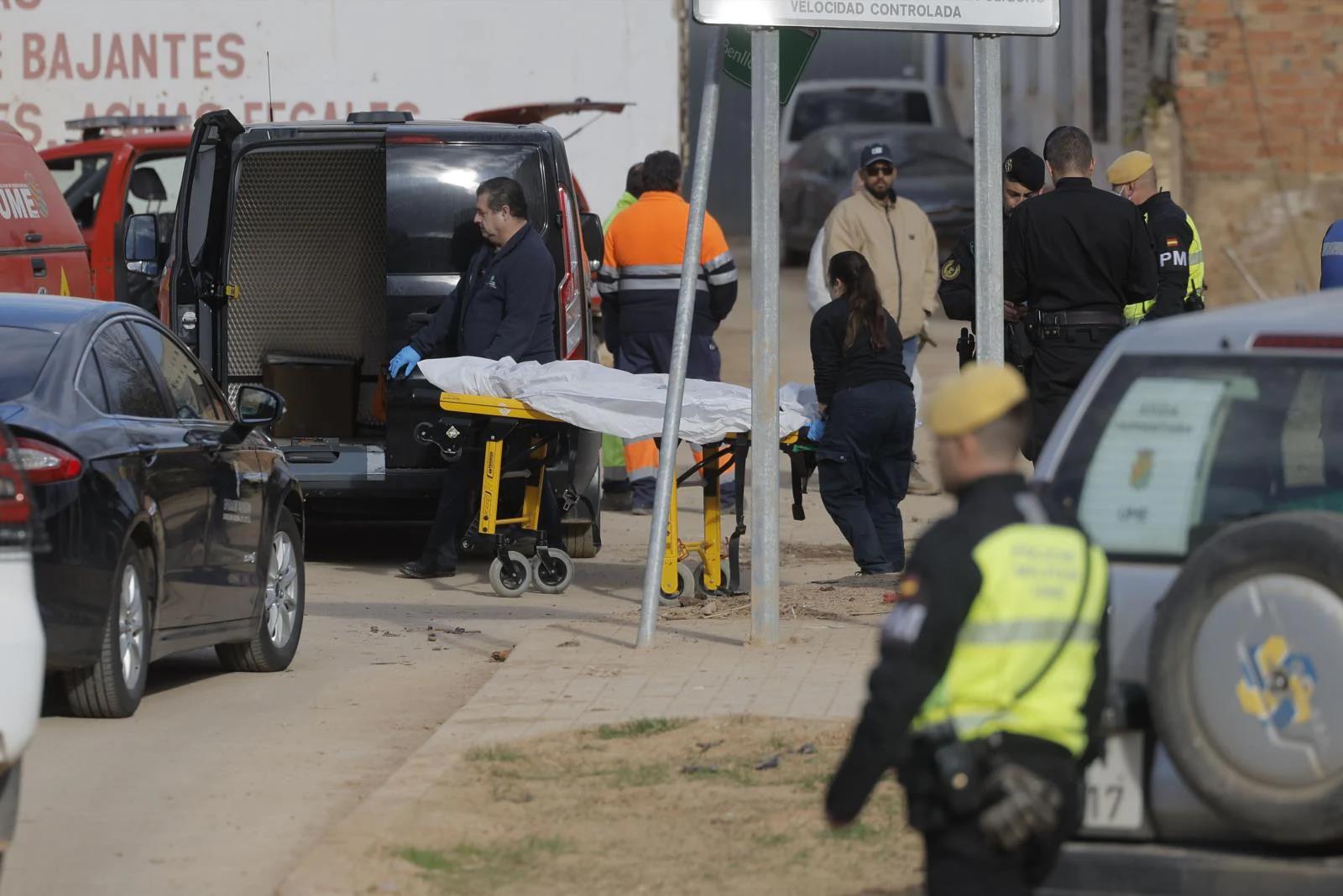 Dos empleados del retén fúnebre introducen el cadáver en un furgón.