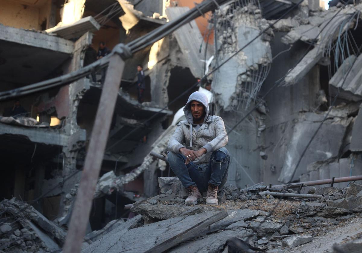 Un hombre palestino sentado en los escombros de un edificio destruido en el campo de refugiados de Nuseirat el 13 de diciembre.