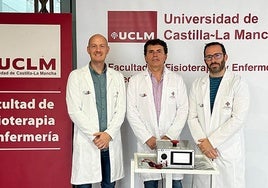 Los tres investigadores posan con el dispositivo de mejora del tratamiento del dolor.