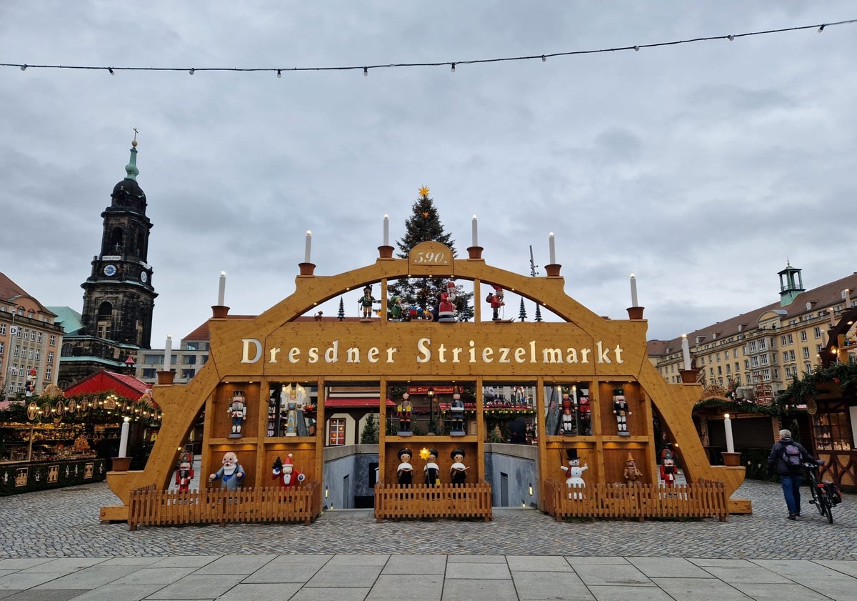 Imagen principal - El típico arco de luces de Dresde da la bienvenida al mercadillo más antiguo del mundo. Una vista nocturna del Striezelmarkt y la tradicional pirámide navideña de madera, que mide casi 15 metros.