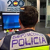 Un policía nacional realiza averiguaciones a través del sistema informático.