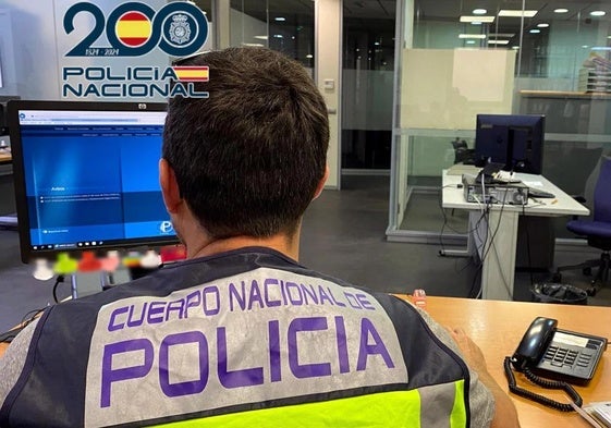 Un policía nacional realiza averiguaciones a través del sistema informático.