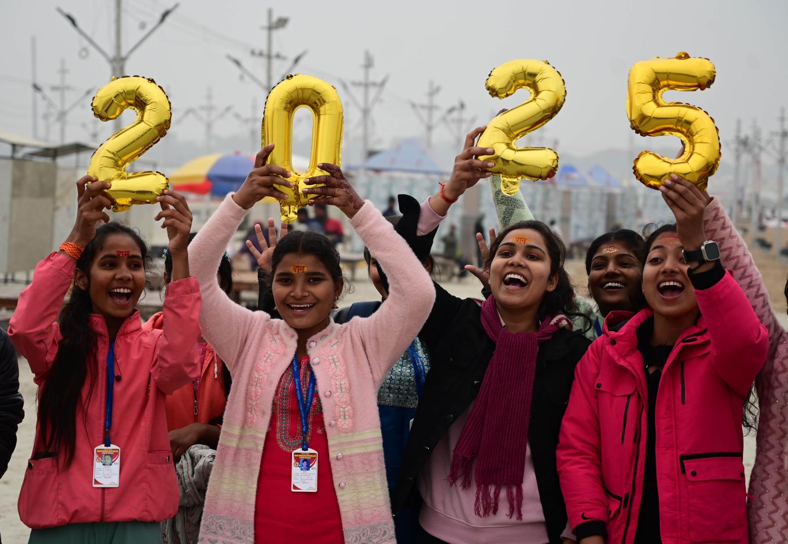 Varias mujeres de la India sostienen globos del 2025