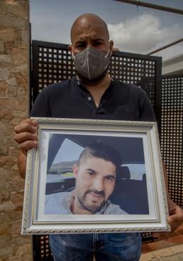 Imagen - Adán Rodríguez, mostrando la foto de su hermano.