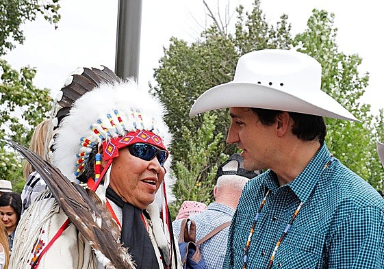 Justin Trudeau, con sombrero vaquero, junto a un líder indio.