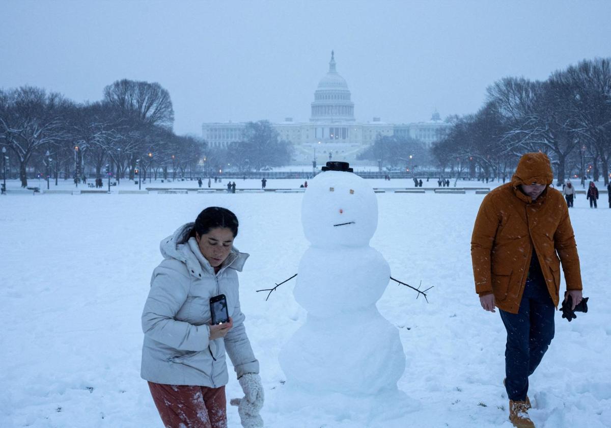 Ciudadanos juegan con la nieve que ha cubierto Washington de un atípico manto blanco.