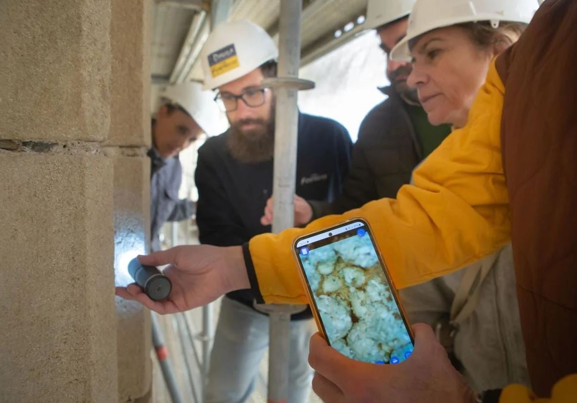 Observando con un microscopio uno de los fósiles aparecidos en la torre, a unos cuarenta y cinco metros de altura.