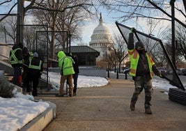 Operarios colocan vallas en los exteriores del Capitolio en los día previos a la investidura de Trump.