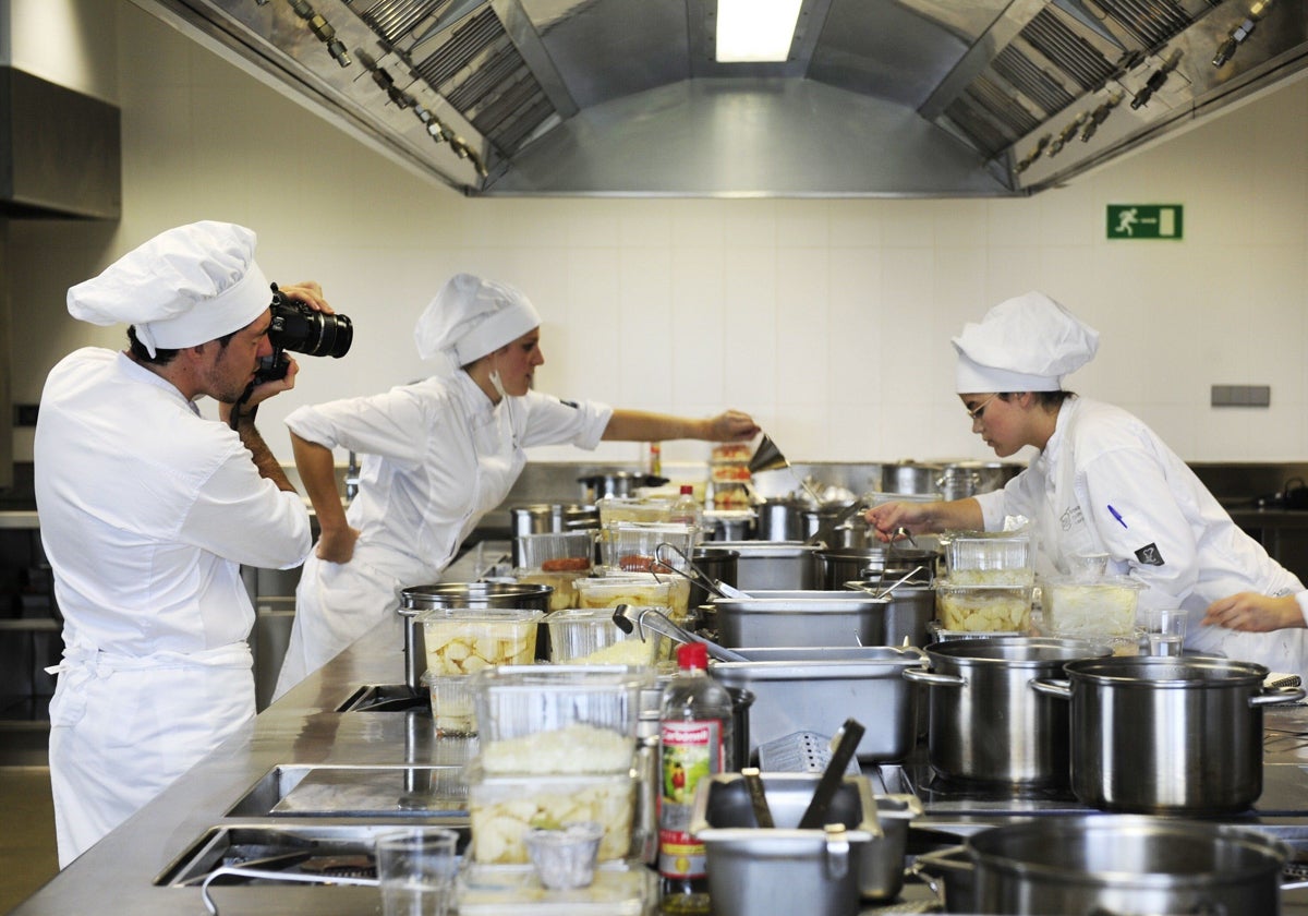 Varios estudiantes superiores españoles realizan prácticas de cocina.