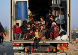 Niños palestinos desplazados son trasladados en un camión de regreso al norte de Gaza.