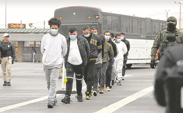 Migrantes son escoltados a través del puente fronterizo internacional de Hidalgo para ser deportados.