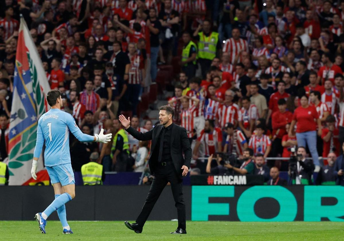 Thibaut Courtois y el Cholo Simeone se saludan tras los mecheros arrojados al portero belga desde la grada en el último derbi del Metropolitano.