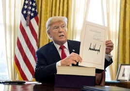 Trump muestra uno de los decretos con su firma.