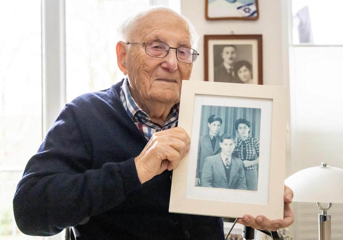 El superviviente del Holocausto Albrecht Weinberg, de 99 años, posa con una foto de su familia.