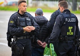 Policías alemanes detienen a un indocumentado en la frontera entre Alemania y Francia.